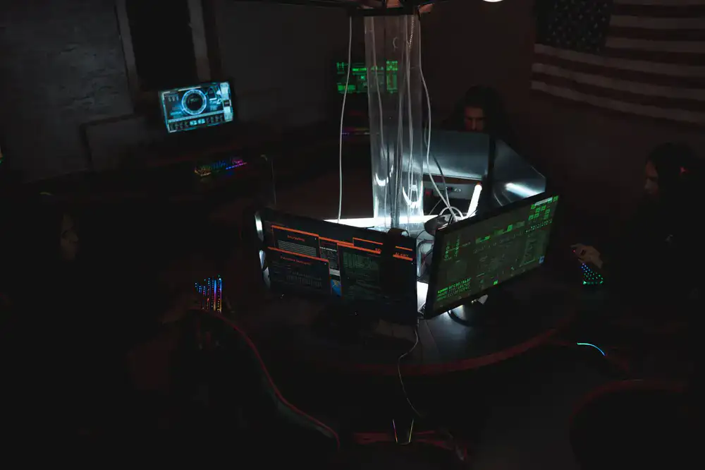 Developers collaborating intensively around multiple monitors during a game jam