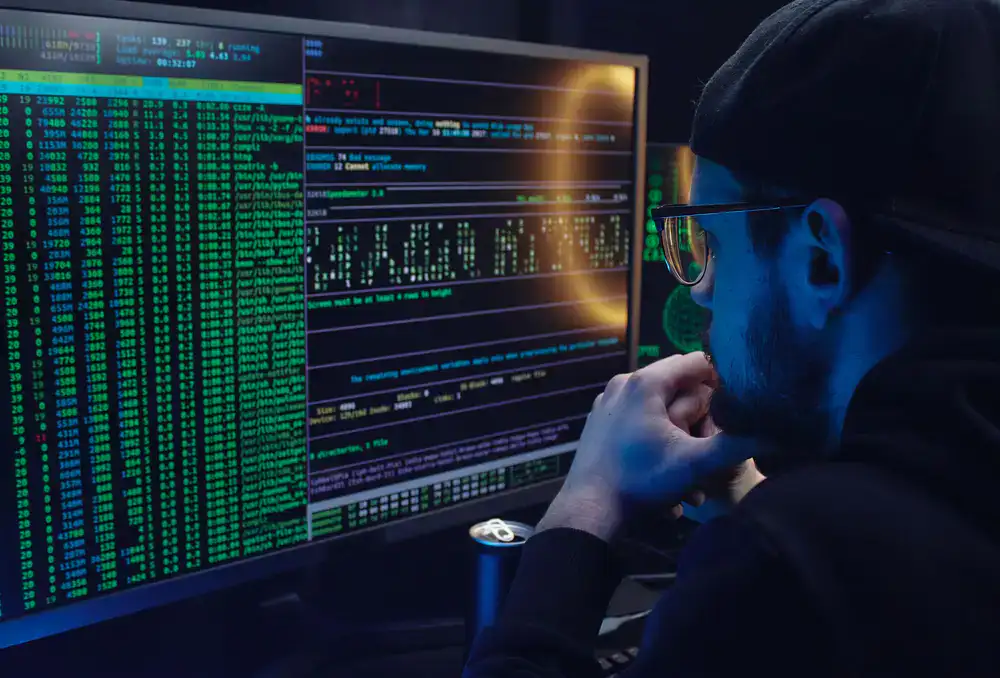 Two developers reviewing code logic on a vertical monitor setup